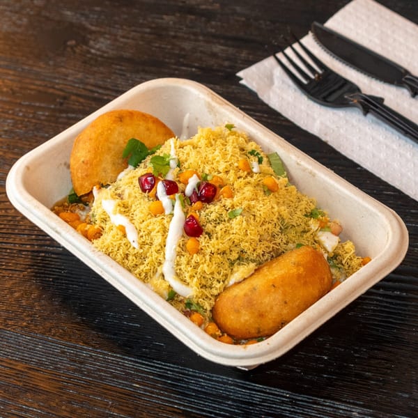 Bombay Baking Co.'s savory Indian snack, sev puri, with two fried pastries, pomegranate, and sauce.