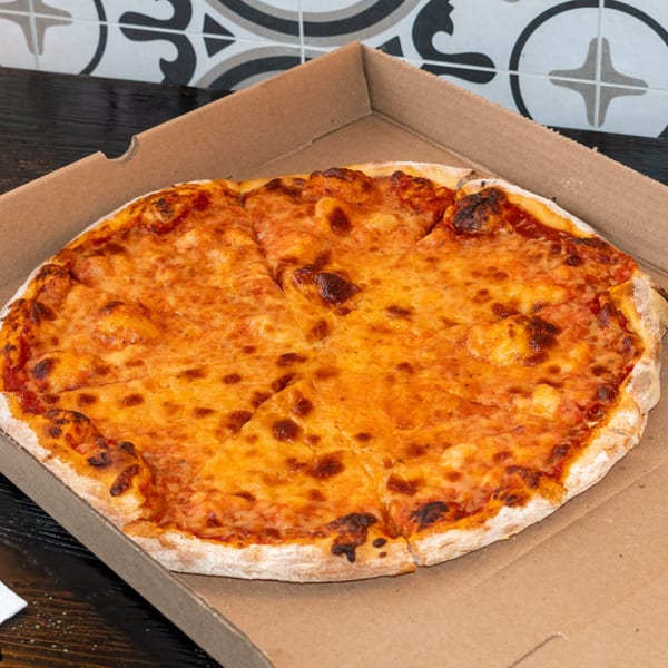 A freshly baked cheese pizza, sliced and presented in a cardboard delivery box from Bombay Baking Co.